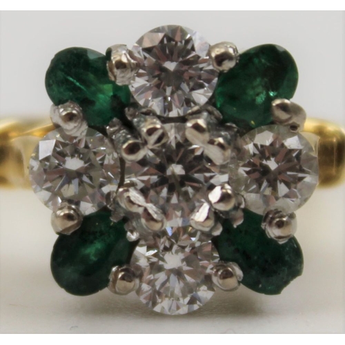 10 - A diamond and emerald ring, set five brilliant cut diamonds in a cross form, having four oval cut em... 