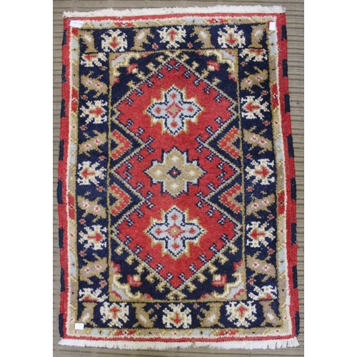 246 - A red and blue ground geometric patterned small hearth rug