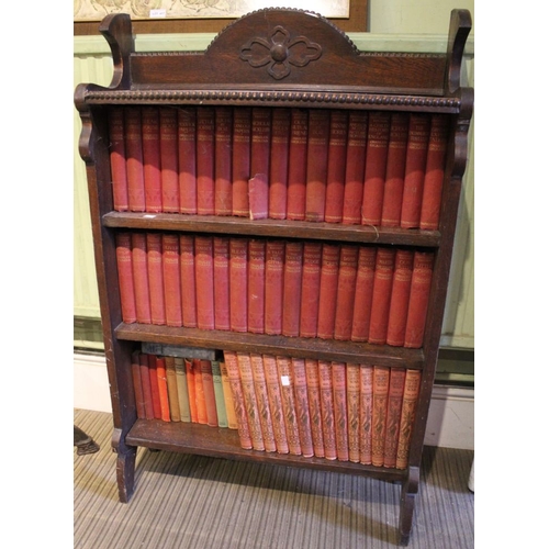 215 - An oak floor standing open three shelf book case well stocked with vintage volumes