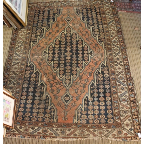 253 - A Persian rug with central terracotta lozenge on a floral blue field 187 x 135 cm