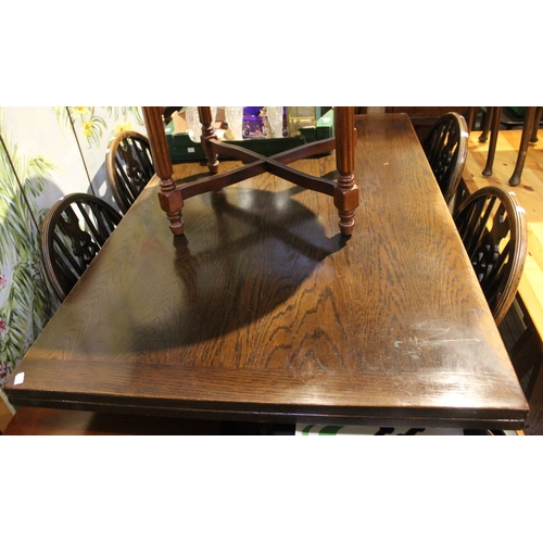 261 - An oak draw leaf dining table with four wheel back chairs 146 x 90 cm