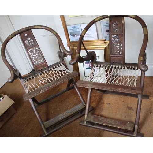 267 - A pair of Chinese hunting chairs, possibly Huanghuali with metal mounts, having horseshoe or Ox bow ... 