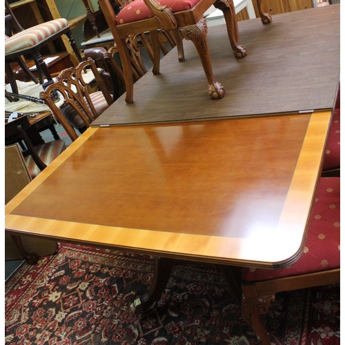 276 - A reproduction mahogany dining table of a Regency design raised on a pair of cluster column supports... 