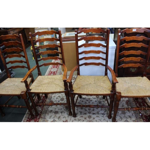 295 - A set of four ladderback rush seated dining chairs to include two carvers