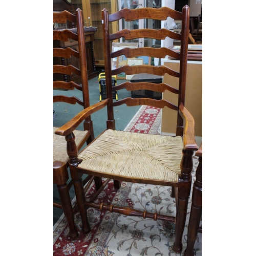 295 - A set of four ladderback rush seated dining chairs to include two carvers