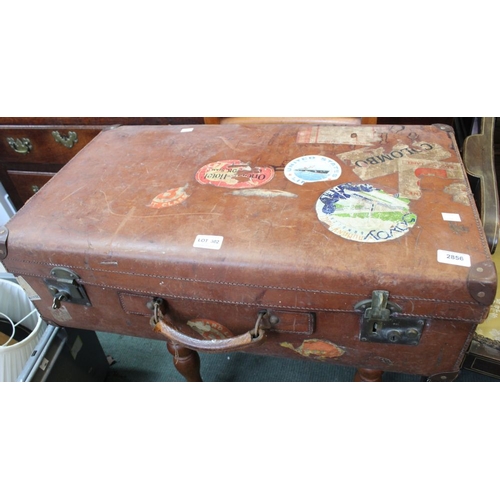 302 - A vintage leather suitcase with various travel stickers