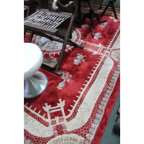 311 - A Chinese carved design floor carpet on a crimson ground 246 x 310 cm