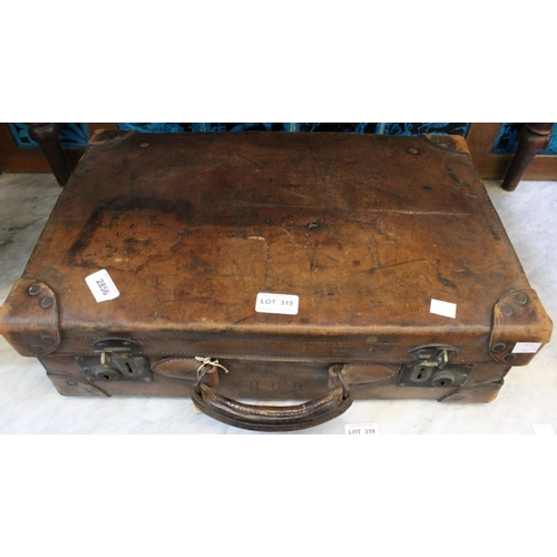 318 - A vintage leather small sized suitcase, initialled HGB, with some interesting photographic contents