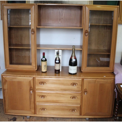 399 - An Ercol sideboard fitted glazed cupboards and shelves over a base of three drawers and two cupboard... 