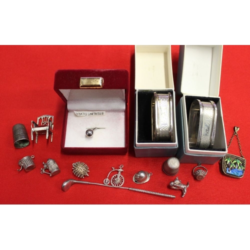 4 - Two silver napkin rings each in boxes, two silver thimbles, silver miniature armchair, various charm... 