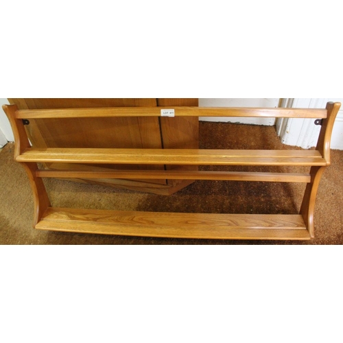 411 - An Ercol elm wall hanging shelf unit