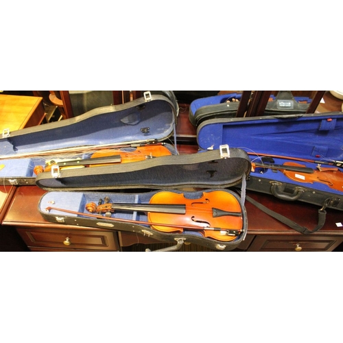 419 - A collection of three violins in cases