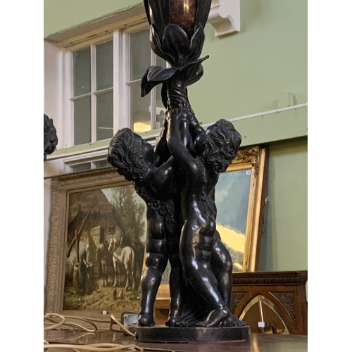 341 - An impressive pair of French bronzed effect table lamps, formed as three putti supporting a flower, ... 