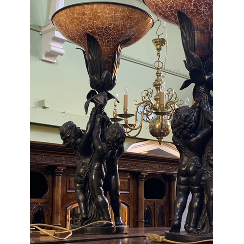 341 - An impressive pair of French bronzed effect table lamps, formed as three putti supporting a flower, ... 