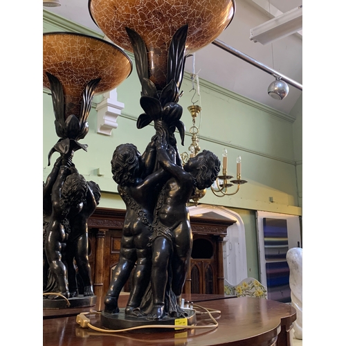 341 - An impressive pair of French bronzed effect table lamps, formed as three putti supporting a flower, ... 