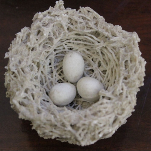 201 - An early Bristol biscuit porcelain birds nest, containing three eggs, 7.5cm dia