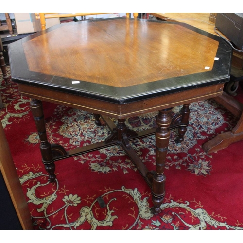 344 - An octagonal occasional table / dining table on four supports with casters