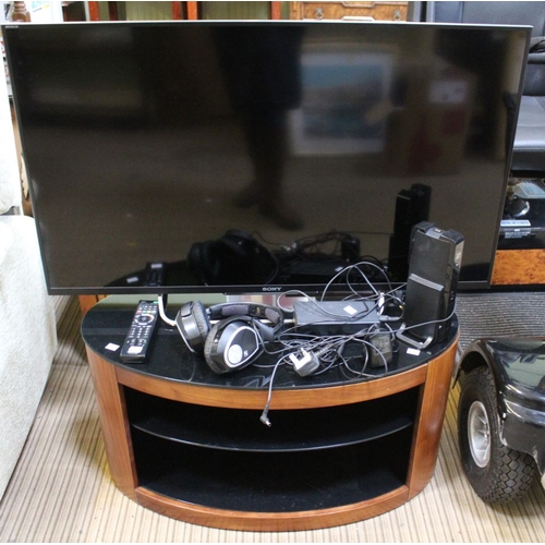 185 - An oval black glass TV stand together with a Sony Bravia 42