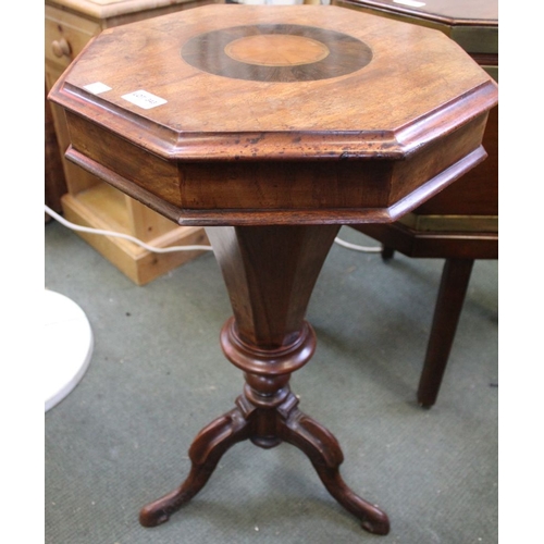 343 - A 19th century mahogany needle work table. The octagonal hinged lid opening to reveal papered interi... 