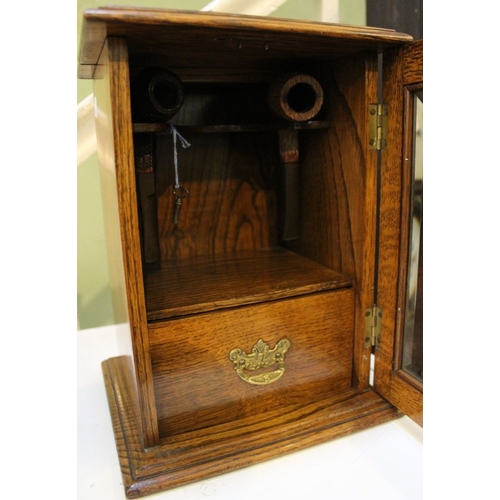 68 - A wooden pipe stand, with glazed door and tobacco drawer, contains two pipes, lockable with key