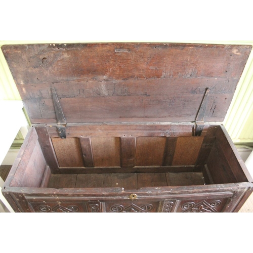 107 - An early 18th century oak coffer, with triple carved panel front, on stile supports, 124cm