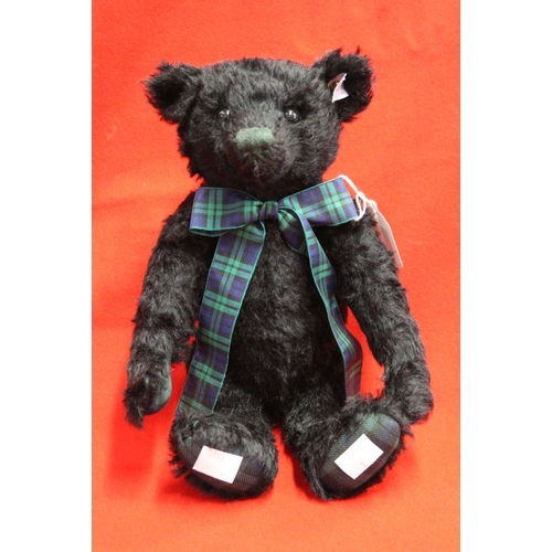 263 - A Steiff musical black mohair bear, with tartan bow and pads, having white limited edition label, pl... 