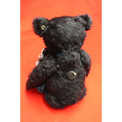 263 - A Steiff musical black mohair bear, with tartan bow and pads, having white limited edition label, pl... 