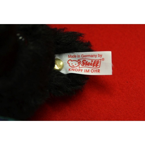 263 - A Steiff musical black mohair bear, with tartan bow and pads, having white limited edition label, pl... 