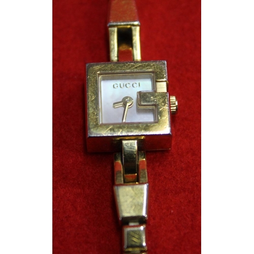 346 - A Gucci plated cocktail wristwatch, together with a Pierre Cardin, costume jewellery necklace and ea... 