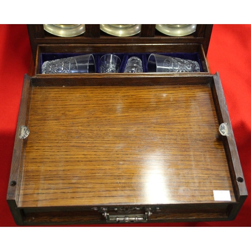 355 - An Edwardian oak Tantalus cabinet, contains three cut glass spirit decanters, various glasses, cabin... 