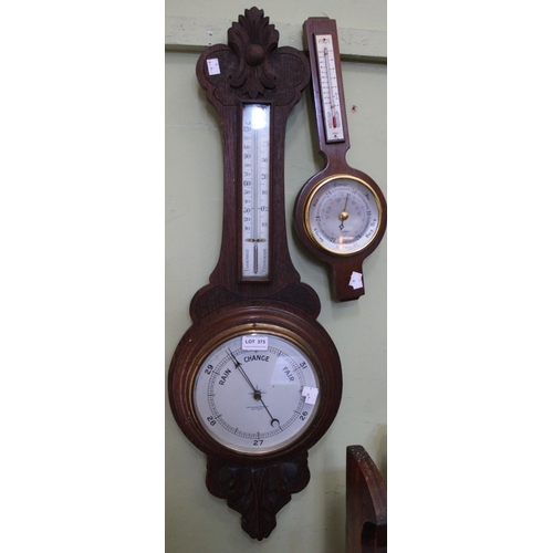 373 - Two wall mounting banjo barometers with thermometers, the larger in a carved oak case