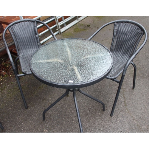 652 - A small circular outdoor glass bistro table together with two chairs