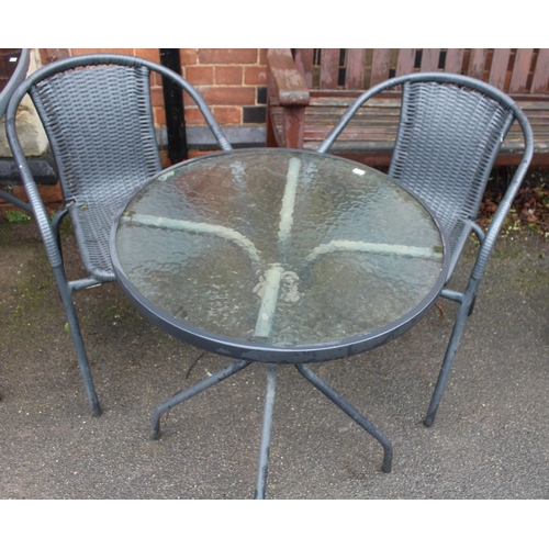 653 - A small circular outdoor glass bistro table together with two chairs