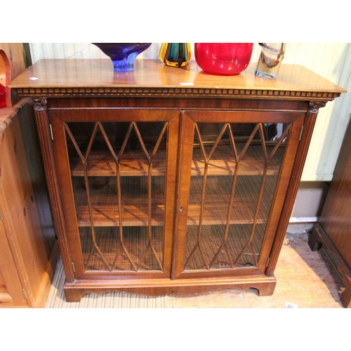 143 - A mahogany bookcase, fitted two glazed doors, flanked by fluted columns on bracket feet, 102cm