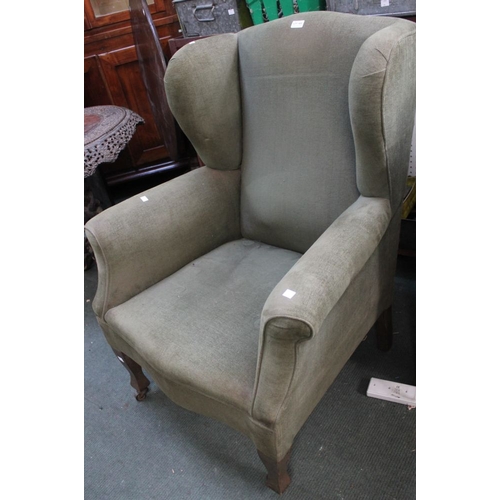 271 - A green upholstered wing back easy chair