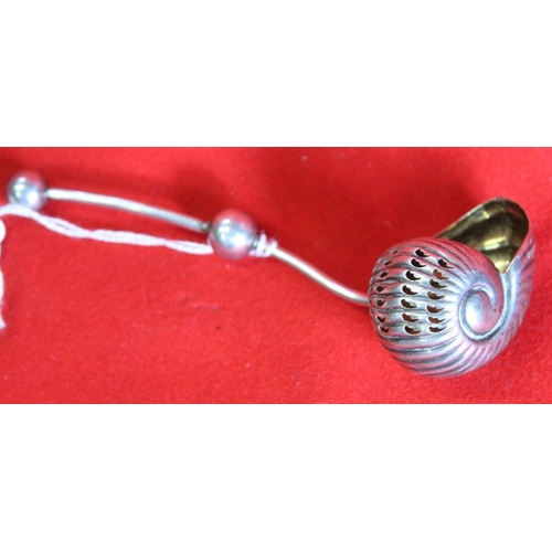 37 - A white metal sifting ladle, the bowl in the form of a shell with gilded interior