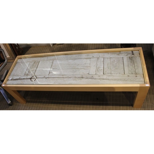 438 - A Moroccan panel, set into a beech framed coffee table with glazed top, 152cm x 49cm