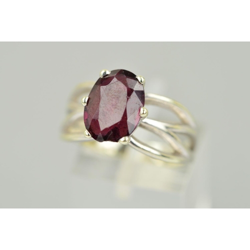 117 - A 9CT WHITE GOLD GARNET RING, the oval garnet within a six claw setting to the openwork shoulders, 9... 