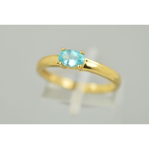 135 - A 9CT GOLD GEM RING, the oval shape gem assessed as apatite within a four claw setting to a plain ba... 