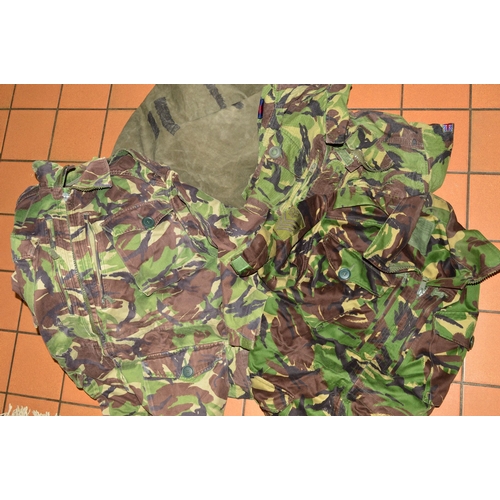 564 - A GREEN CANVAS ARMY ISSUE BAG, containing four pairs of camo trousers, combat NATO DPM and four comb... 