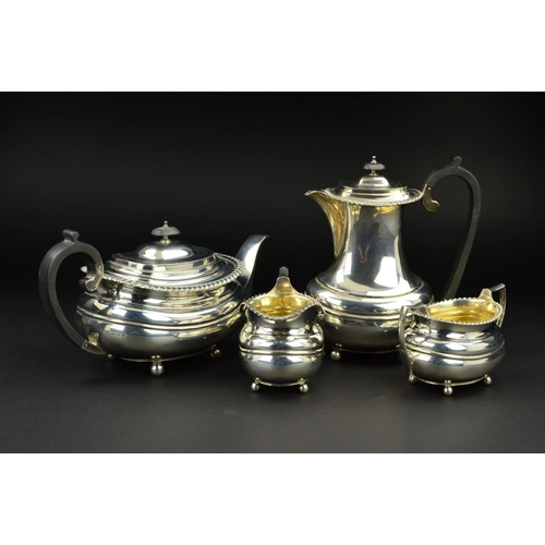 126 - A GEORGE V SILVER FOUR PIECE TEA SERVICE, of oval form, gadrooned rims, over a lobed girdle, on four... 