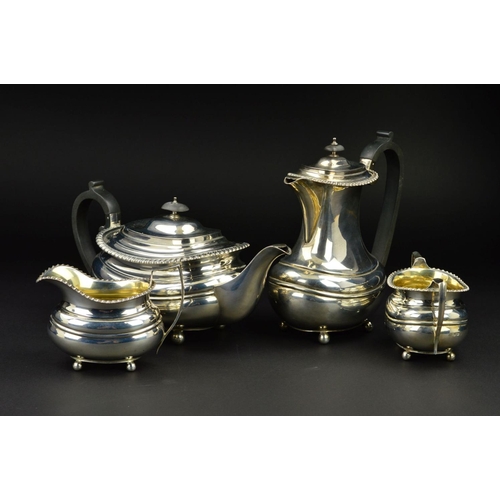 126 - A GEORGE V SILVER FOUR PIECE TEA SERVICE, of oval form, gadrooned rims, over a lobed girdle, on four... 