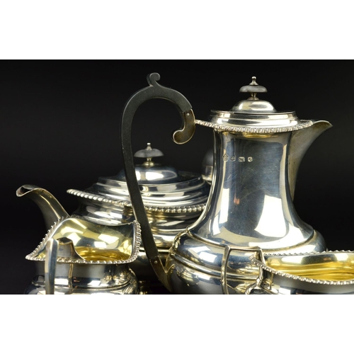 126 - A GEORGE V SILVER FOUR PIECE TEA SERVICE, of oval form, gadrooned rims, over a lobed girdle, on four... 