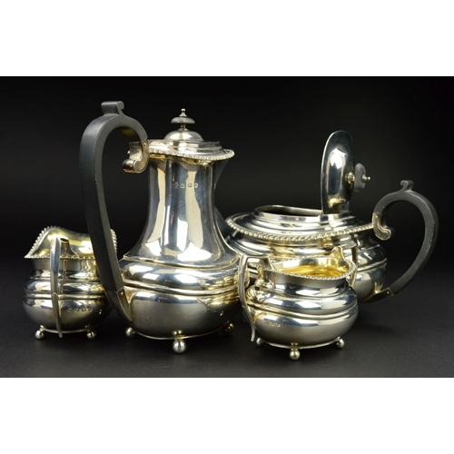 126 - A GEORGE V SILVER FOUR PIECE TEA SERVICE, of oval form, gadrooned rims, over a lobed girdle, on four... 