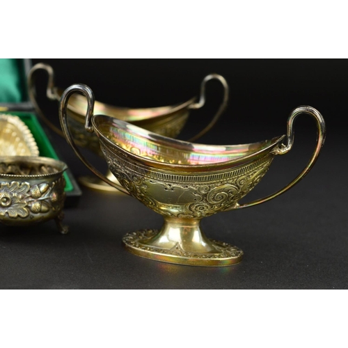 130 - A PAIR OF VICTORIAN SILVER OVAL TWIN HANDLED PEDESTAL SALTS, worn gilt interiors, foliate repousse d... 