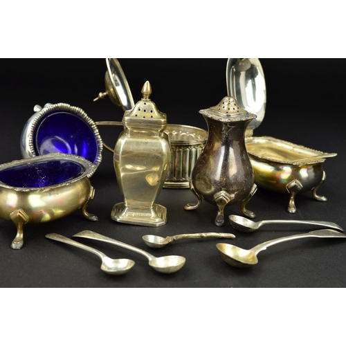 132 - A PARCEL OF SILVER CRUET ITEMS, including a three piece set of shaped oval form with cast rims and o... 