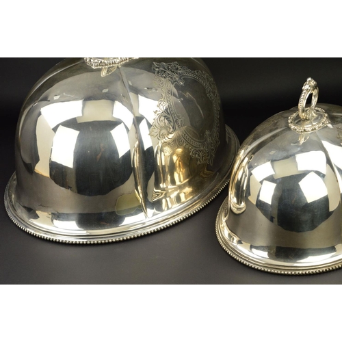 137 - A GRADUATED SET OF TWO VICTORIAN SILVER PLATED OVAL MEAT DOMES, beaded and foliate cast handles, bea... 