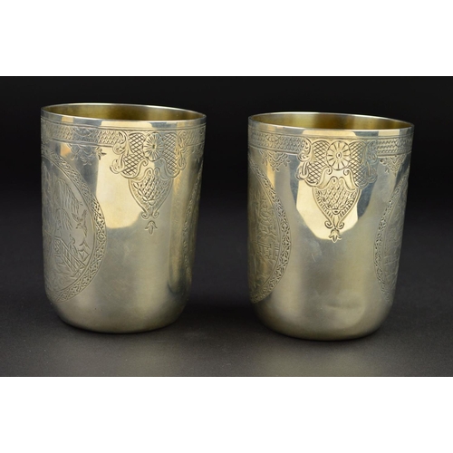 142 - A PAIR OF VICTORIAN SILVER CYLINDRICAL BEAKERS, gilt interiors, engraved bands to the rims with loze... 