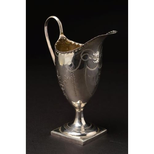 151 - A GEORGE III SILVER HELMET SHAPED PEDESTAL CREAM JUG, strap handle, crimped rim, bright cut decorati... 