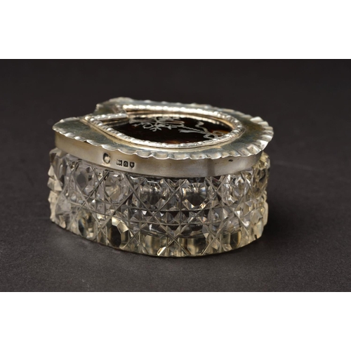 152 - AN EDWARDIAN HORSESHOE SHAPED SILVER TOPPED GLASS TRINKET BOX, the pull off cover with crimped rim a... 